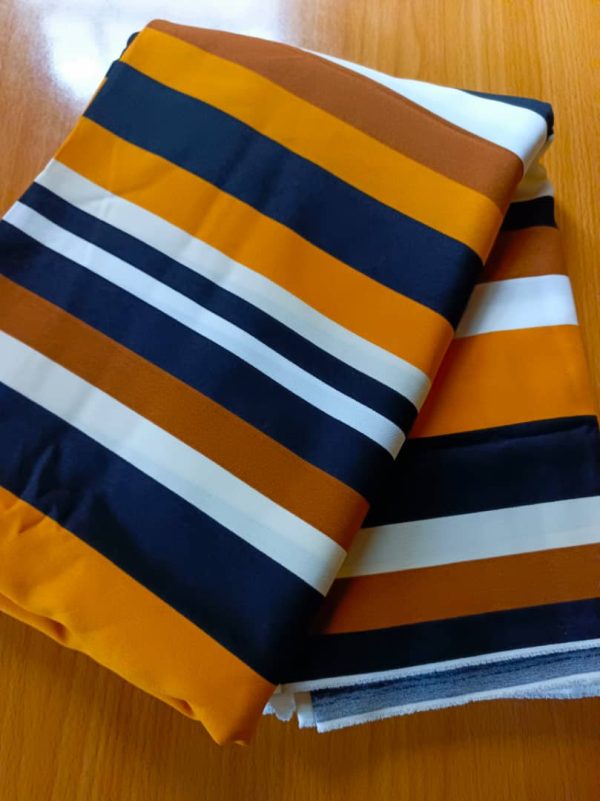 Premium Crepe fabric with bold burnt orange, navy blue, and white stripes. Perfect for elegant dresses, abayas, and stylish modest outfits.