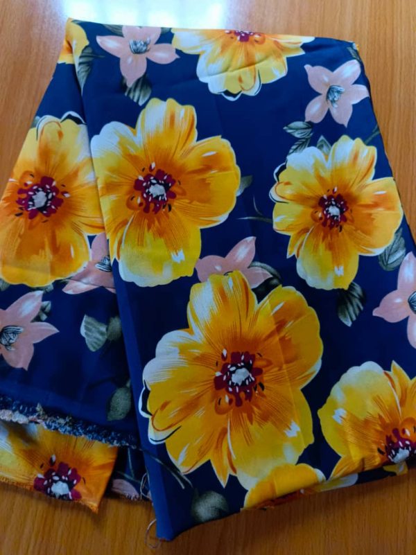 Luxurious fabric with bold yellow and peach floral patterns on a deep navy blue background. Ideal for elegant gowns, abayas, and stylish modest outfits.